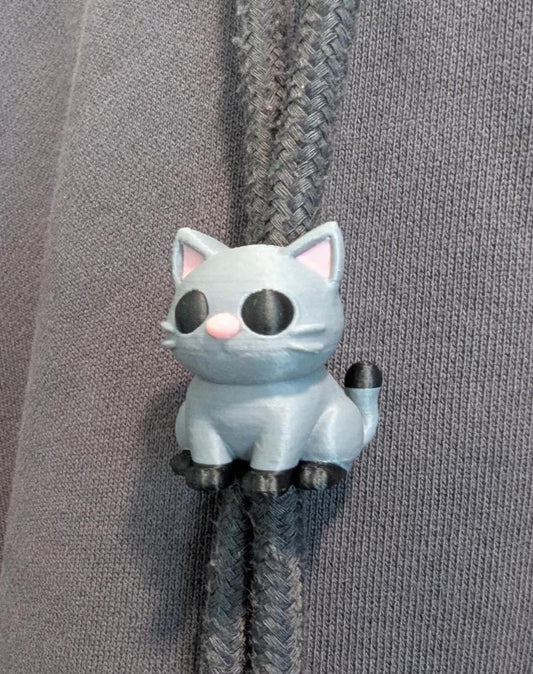 Cat-shaped zipper pull on a gray fabric background