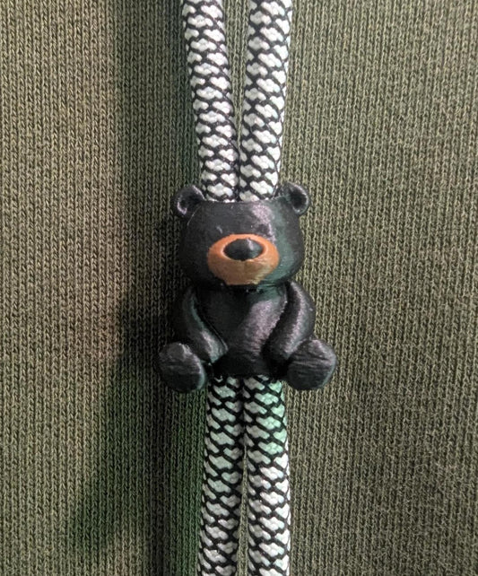 Bear-shaped zipper pull on a green background